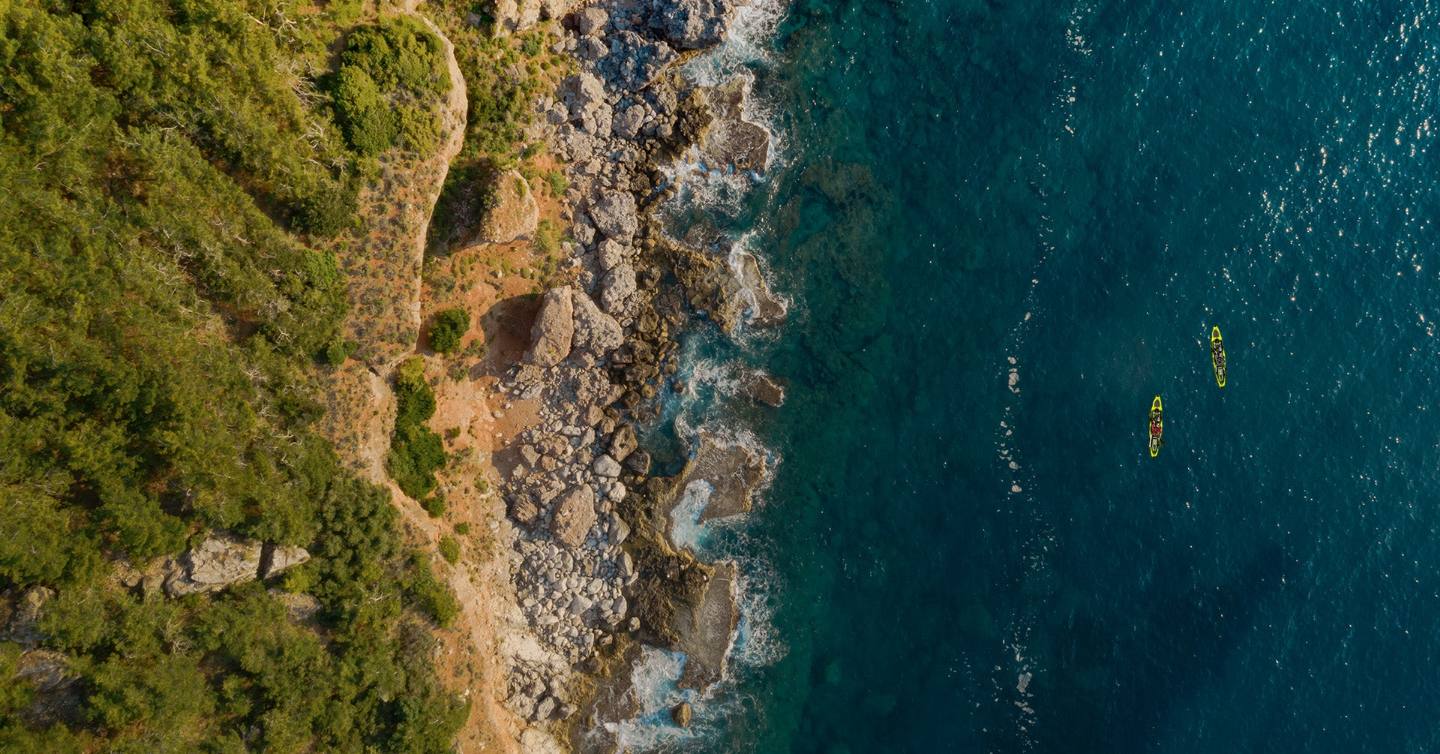 Two Cajo kayaks on clear coastal water, seen from above